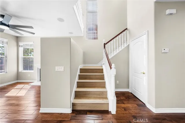 an empty room with window and ceiling fan