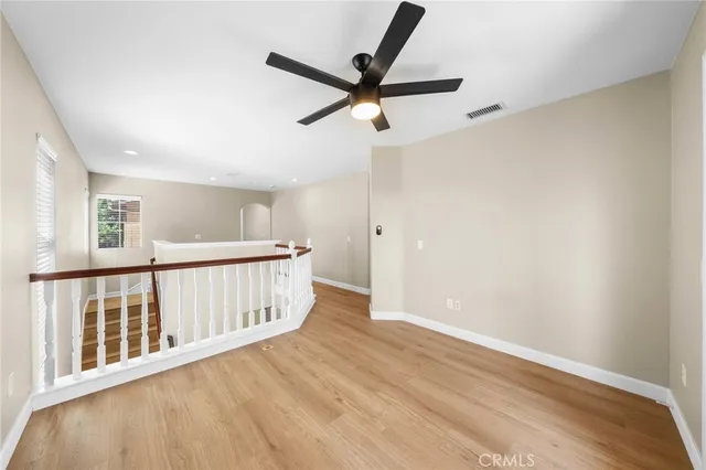 a view of empty room with wooden floor and window