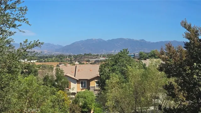 an empty room with wooden floor ceiling fan and windows
