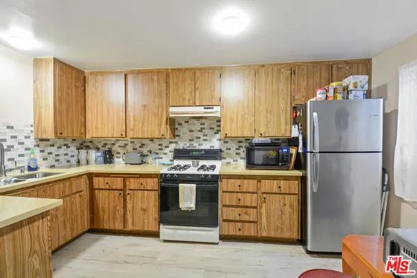 a kitchen with a sink refrigerator and cabinets