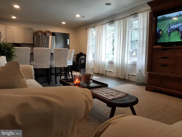 a living room with furniture a flat screen tv and a window