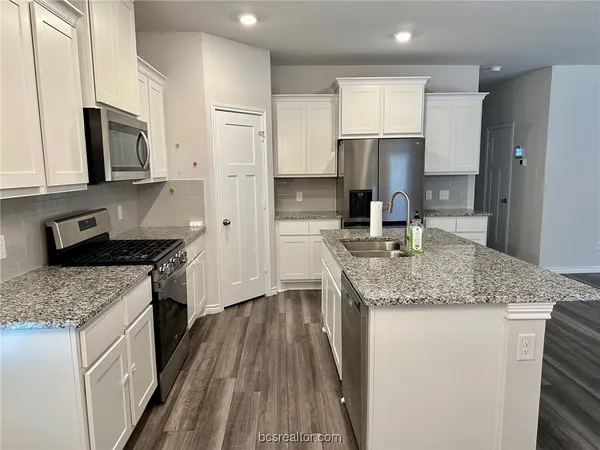 a kitchen with stainless steel appliances granite countertop a sink stove microwave and cabinets