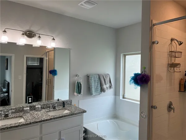a bathroom with a granite countertop sink a toilet and shower