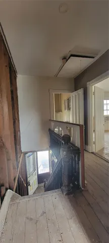 a view of a hallway with wooden floor and chair