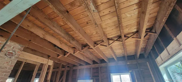 a view of an empty room with wooden floor and windows