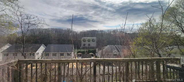 a view of a balcony with wooden floor and fence