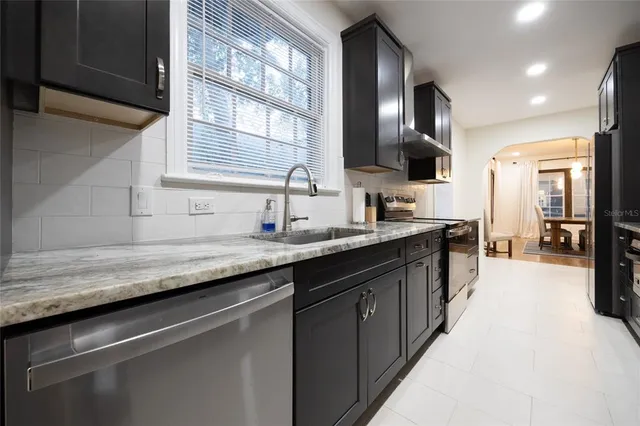 a large kitchen with granite countertop lots of counter space and a sink