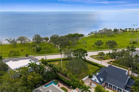 an aerial view of residential houses with outdoor space and ocean view