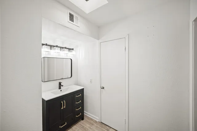 a bathroom with a sink vanity and mirror