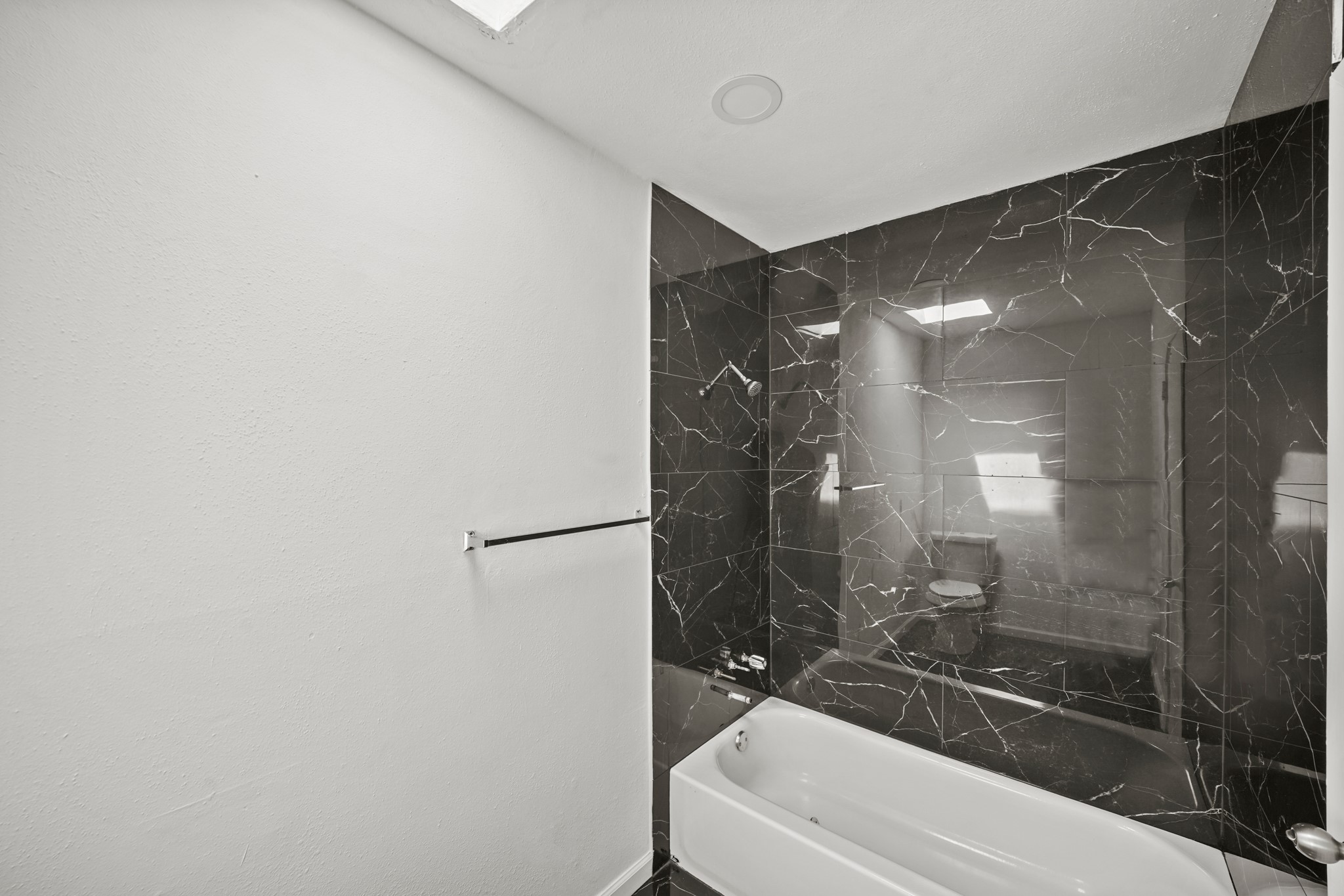 7047 Bissonnet Street, Unit 62 Houston, TX 77074 - Photo 12 of 15 a bathroom with a bathtub and a shower