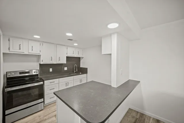 a kitchen with stainless steel appliances granite countertop a stove a sink and a microwave