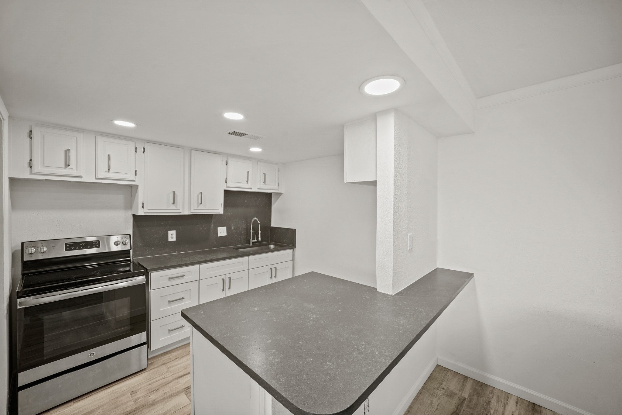 7047 Bissonnet Street, Unit 62 Houston, TX 77074 - Photo 4 of 15 a kitchen with stainless steel appliances granite countertop a stove a sink and a microwave