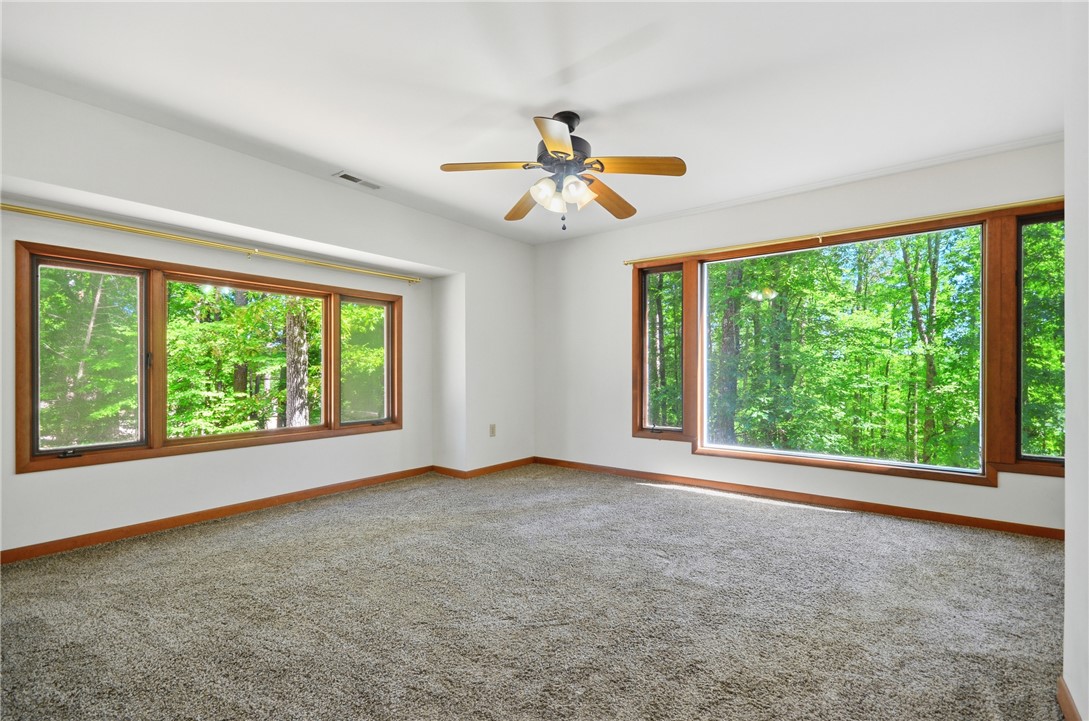 1298 Carradine Road Seneca, SC 29678 - Photo 9 of 43 Large picture windows in the Primary Bedroom highlight the vibrant surrounding forest.