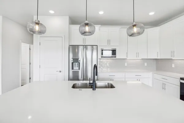 a kitchen with kitchen island stainless steel appliances a large center island a stove and a cabinets
