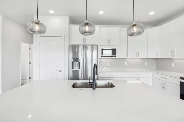 a kitchen with kitchen island stainless steel appliances a large center island a stove and a cabinets