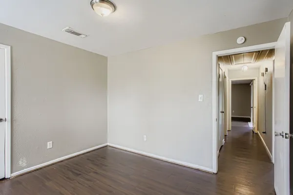a view of an empty room with wooden floor