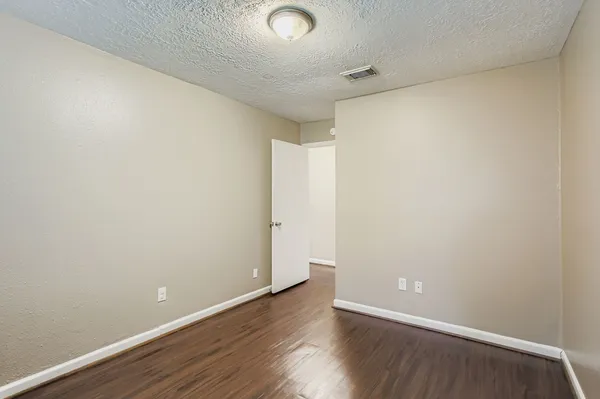 a view of an empty room with wooden floor