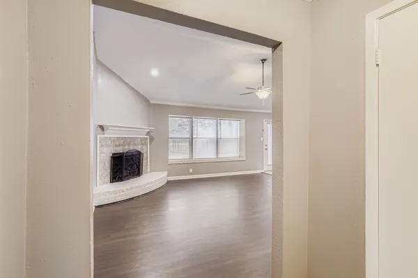 a view of a livingroom with wooden floor and a fireplace