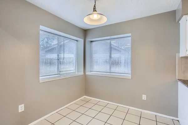 a view of an empty room with window and cabinet