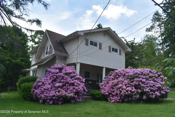 a front view of house with garden and flowers
