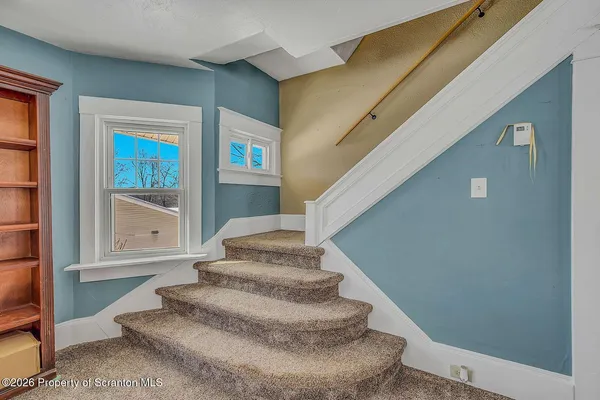a view of staircase with white walls and windows