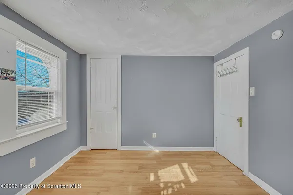 a view of an empty room with window and closet area