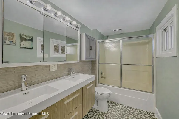 a bathroom with a sink a toilet and shower