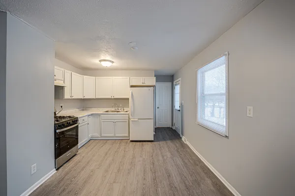 a kitchen with a sink wooden floor and stainless steel appliances