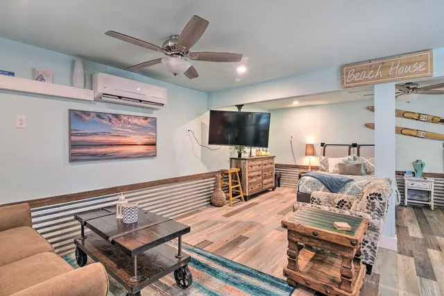 a living room with furniture and a flat screen tv with wooden floor