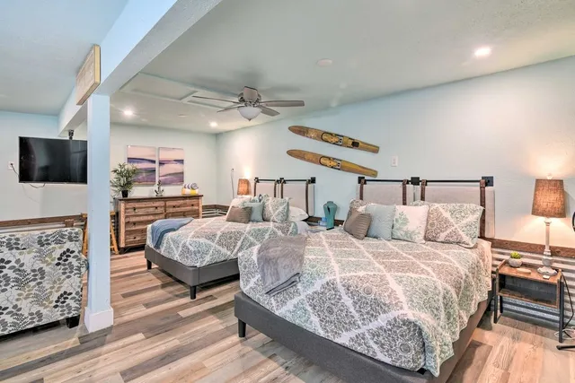 a bedroom with a bed a couch and a flat tv screen on the dresser