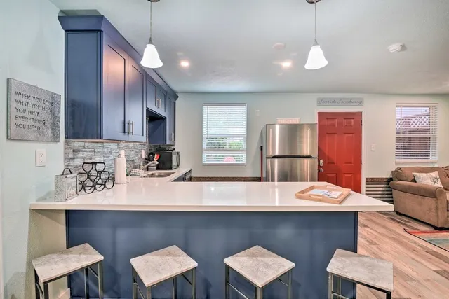 a kitchen with stainless steel appliances wooden cabinets a center island and chairs in it