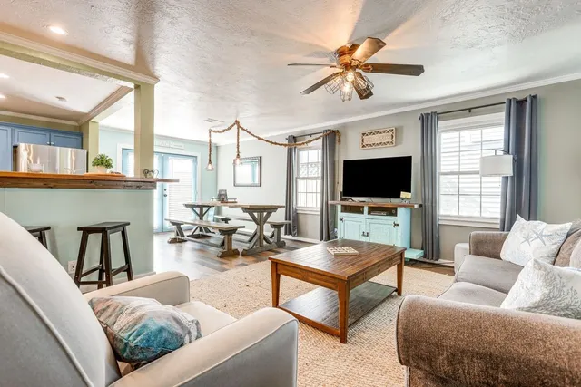 a living room with furniture a flat screen tv and a large window