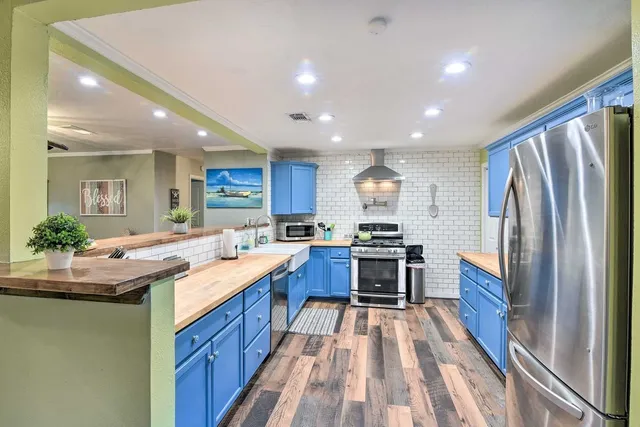 a kitchen with stainless steel appliances granite countertop sink refrigerator and cabinets