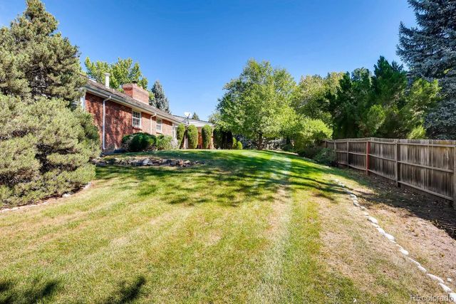 a view of yard with swimming pool and trees in the background