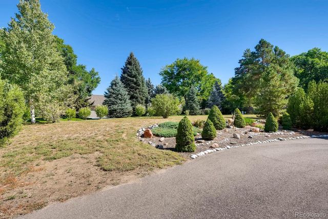 a view of a house with a yard and large tree