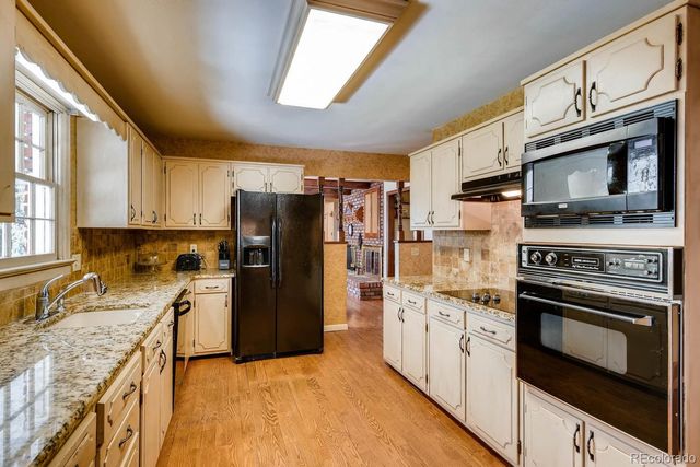 a kitchen with stainless steel appliances granite countertop a refrigerator stove microwave and sink