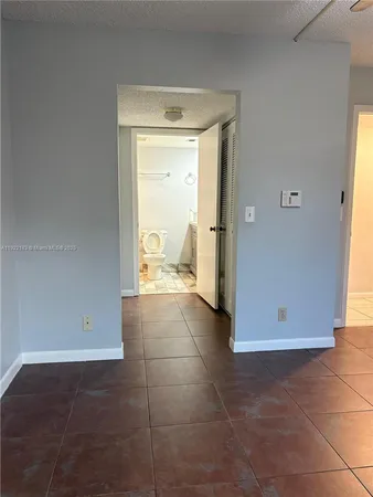 a bathroom with a granite countertop toilet sink mirror and vanity