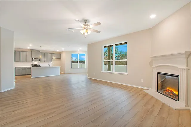 a view of an empty room with a fireplace and a window