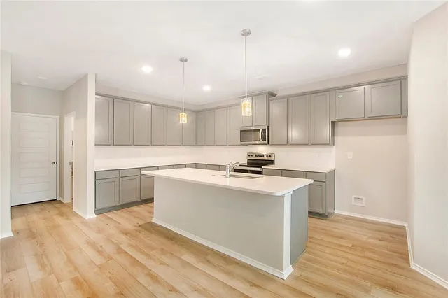 a kitchen with a sink a stove a refrigerator and white cabinets