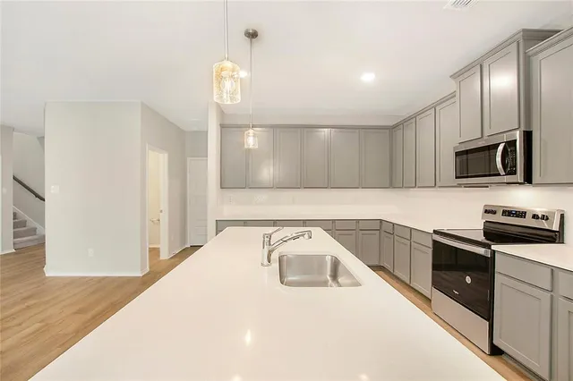a kitchen with granite countertop a sink and steel appliances