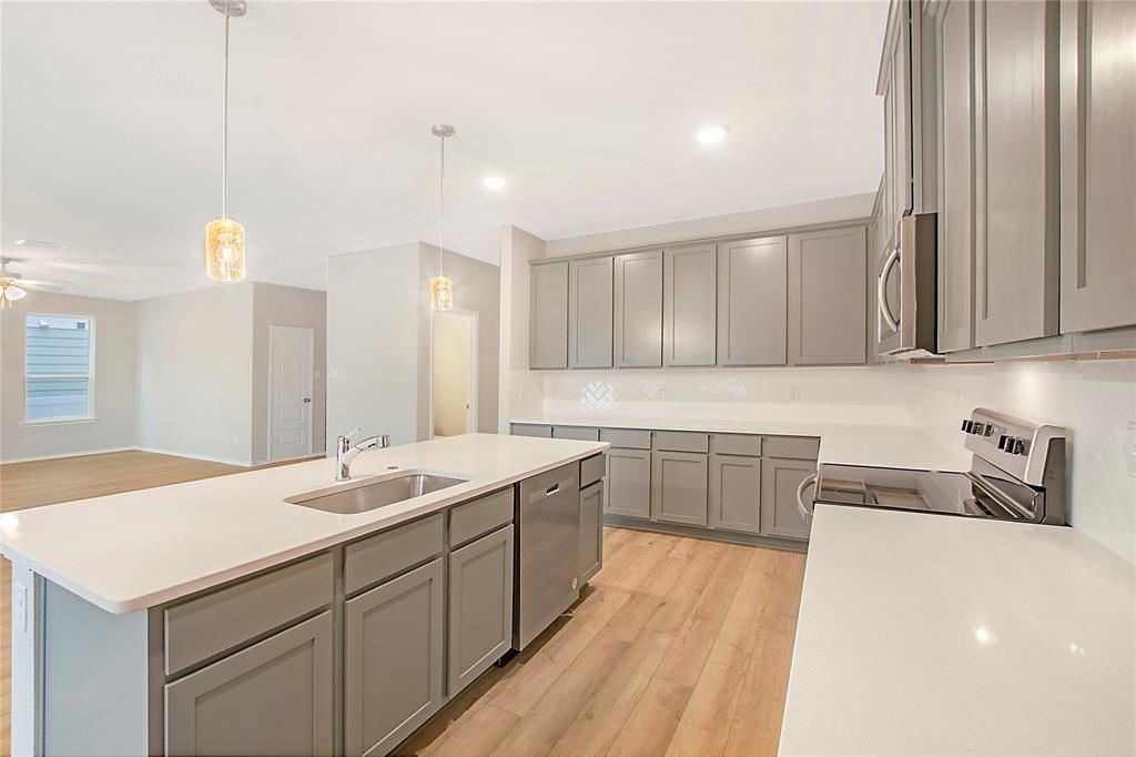 1605 Katharina Avenue Providence Village, TX 76227 - Photo 18 of 35 a kitchen with a sink cabinets and wooden floor