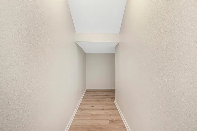 a view of a hallway with wooden floor