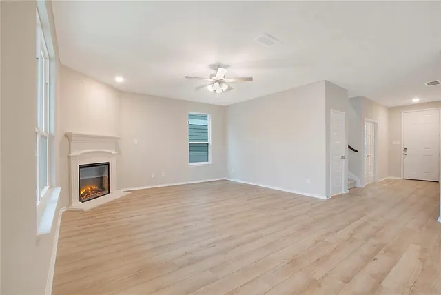 a view of empty room with a fireplace and fan