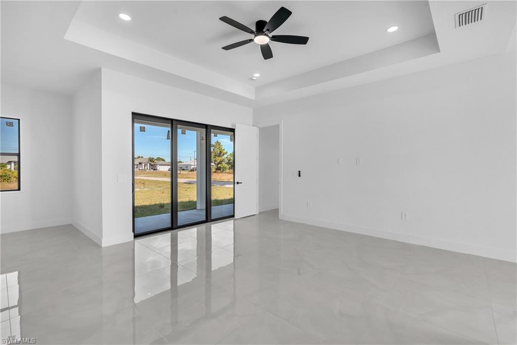 3110 23rd Street Southwest Lehigh Acres, FL 33976 - Photo 13 of 16 Empty room with a tray ceiling, a ceiling fan, and recessed lighting