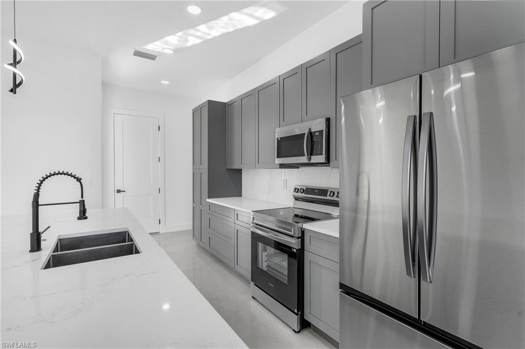 3110 23rd Street Southwest Lehigh Acres, FL 33976 - Photo 5 of 16 Kitchen featuring stainless steel appliances, gray cabinets, recessed lighting, light stone countertops, and light marble finish flooring