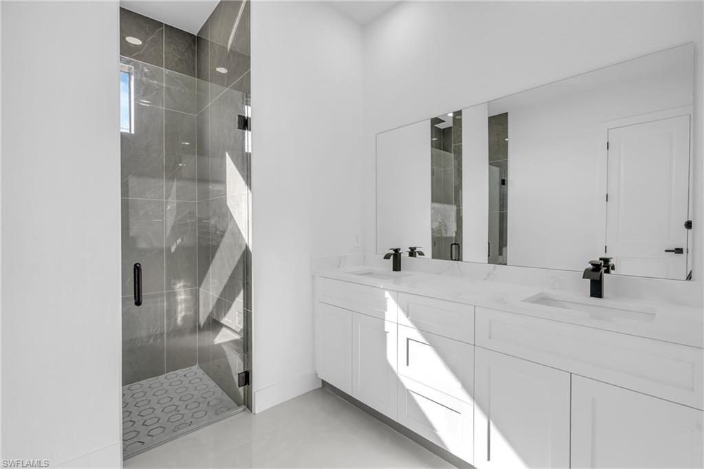 3110 23rd Street Southwest Lehigh Acres, FL 33976 - Photo 7 of 16 Bathroom featuring a marble finish shower and double vanity