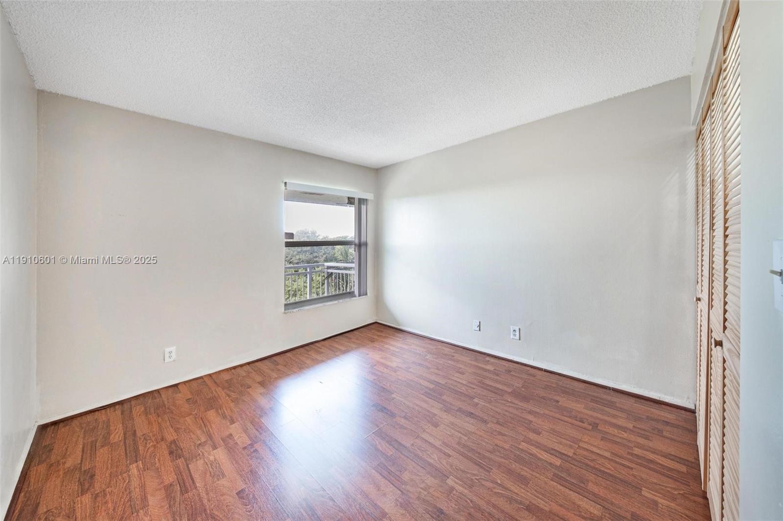 405 South Pine Island Road, Unit 405D Plantation, FL 33324 - Photo 16 of 28 an empty room with wooden floor and windows