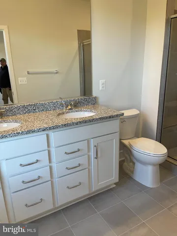a bathroom with a granite countertop toilet sink and mirror