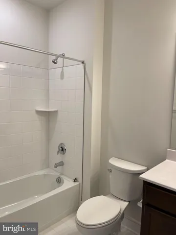 a white toilet and tub sitting next to a bathroom sink