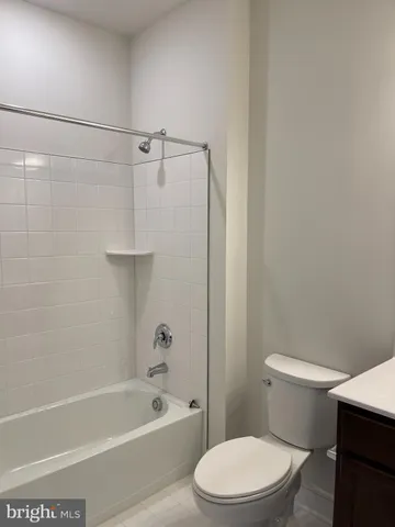 a white toilet and tub sitting next to a bathroom sink